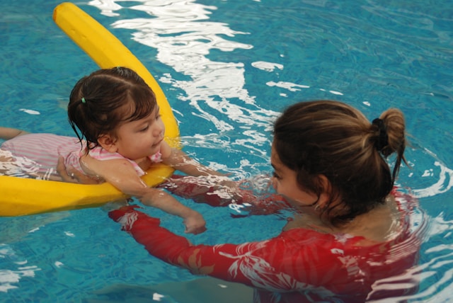 Babyschwimmen und kognitive Entwicklung Säugling beim betreuten Schwimmtraining im Wasser